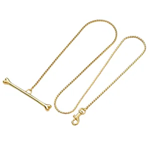 Close-up detail of the gold-tone metal pet leash featuring a unique bone handle and secure clasp.