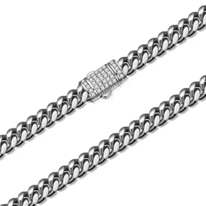 Close-up detail of stainless steel cuban link chain with paved crystal clasp for men.