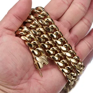 Detailed close-up view of a bold gold Cuban link chain featuring dragon clasp held in hand.