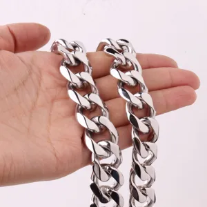 Closeup of heavy silver stainless steel cuban chain necklace detail showing metal polish.