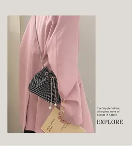Close-up of a stylish rhinestone drawstring evening bucket bag with pearl and chain details