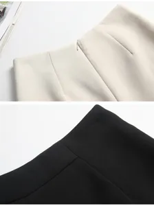 Dettaglio ravvicinato di pantaloncini a trapezio a vita alta in nero e crema.