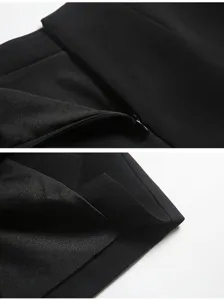 Primi piani di pantaloncini neri a vita alta con cerniera invisibile e orlo rifinito