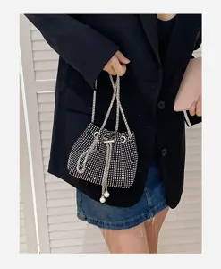 Detail view of a black rhinestone-studded bucket bag with elegant chain straps.