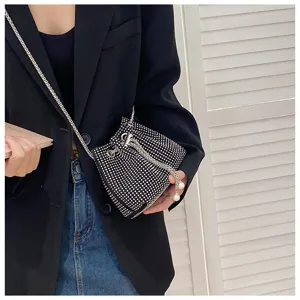 Detail of luxurious rhinestone drawstring evening bucket bag with chain strap and pearls.