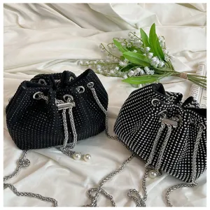 Macro view of black and silver rhinestone-studded evening bucket bags with chain straps.