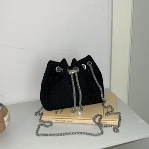 Sparkling black rhinestone bucket bag with silver chain strap and pearl drawstring detail