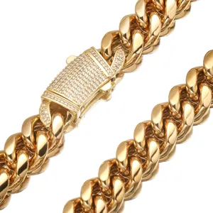 Close-up detail of a heavy gold stainless steel Cuban link chain with a paved rhinestone clasp.