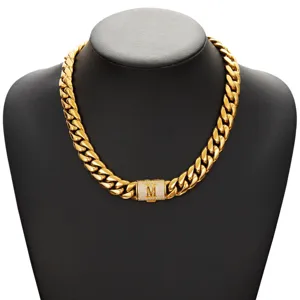 Gold cuban link necklace detail featuring a pavé rhinestone letter M flip clasp design.