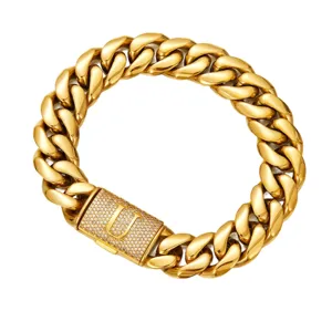 Close-up detail of the heavy gold Cuban link chain necklace with a paved letter U clasp.
