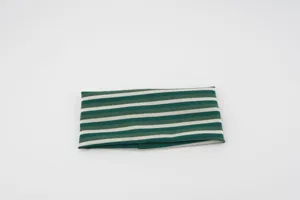 Detailed view of green and white striped knit headband, stretchy fabric texture close-up.