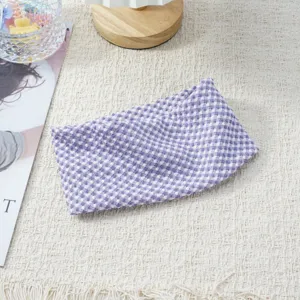 Detail view of the purple and white checkered elastic headband, showing textured fabric close-up.
