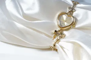 Close-up detail of a vintage gold heart watch with sparkling rhinestones and a delicate bow.