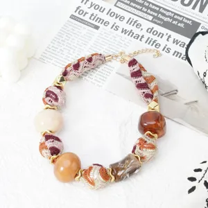 Detailed view of a bohemian style Maillard fabric beaded necklace with mixed resin beads.