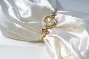Detail view of the gold heart quartz watch featuring a bow bracelet and sparkling rhinestone dial.