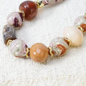 Bohemian style fabric beaded necklace detail, featuring Maillard colored resin cloth beads.