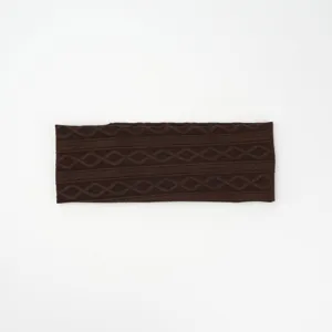 Detailed view of the dark brown knitted headband featuring classic cable and diamond patterns.