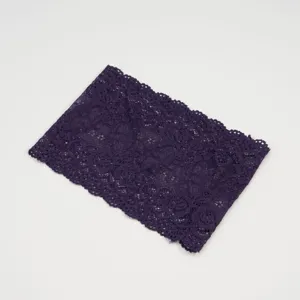 Gedetailleerd uitzicht op de brede paarse kanten haarband, met een fijn opengewerkt bloemenpatroon.