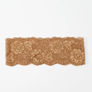 Detailaufnahme der eleganten braunen elastischen Spitzenborte mit filigranem Blumenmuster.