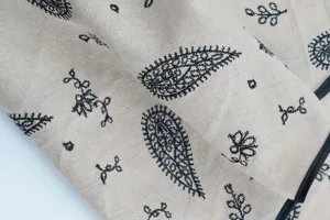 Close-up detail of vintage ethnic paisley embroidered cotton bandana fabric texture.