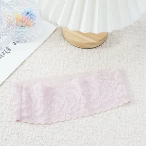 Detailed view of the pink lace headband showing delicate floral wavy edges and elastic fabric.