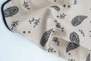 Close-up detail of cotton paisley embroidered vintage floral triangle headscarf fabric.