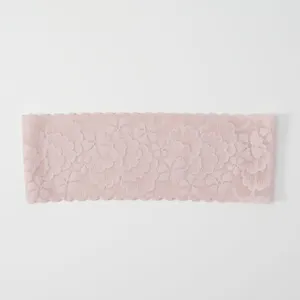 Detailed view of the pink lace headband featuring a delicate floral pattern and scalloped edge.