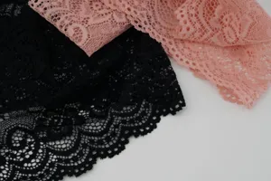 Gedetailleerde close-up van brede holle kanten hoofdband met delicate bloemmotieven en elastische textuur.