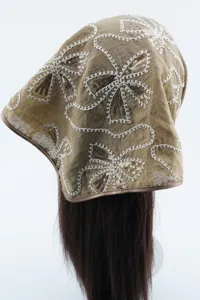 Detalle de pañuelo bordado con lentejuelas champán, envoltura de pelo de encaje floral retro.