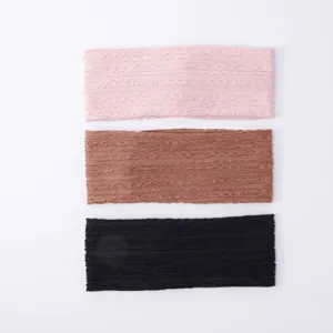 Close-up detail of soft knit headbands in pink, brown and black, elastic and comfortable.