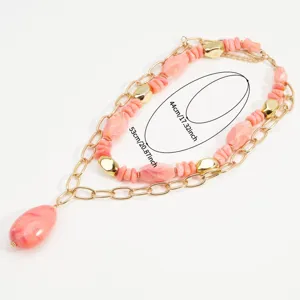 Vista detallada del collar multicapa de cuentas con piedras rosas y cadenas doradas con medidas.