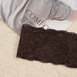 Detailopname van donkerbruine kanten hoofdband met elegant bloemenpatroon en gegolfde rand.