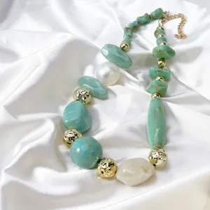 Close-up detail of trendy green resin irregular beads and gold metal texture necklace.