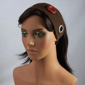 Punk style brown fabric headband featuring red button and metal ring details close-up shot