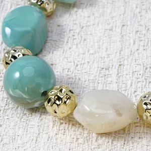 Detail view of the stylish resin bead necklace featuring turquoise and beige irregular stones.