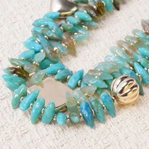 Detalle de collar multicapa con cuentas de concha turquesa, joyería boho de playa.