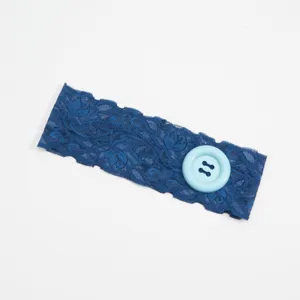 Gedetailleerde close-up van de blauwe kant hoofdband met een grote lichtblauwe decoratieve knop.