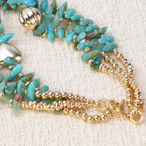 Detalle de collar de cuentas de fragmentos de turquesa multicapa, hermosas joyas doradas.
