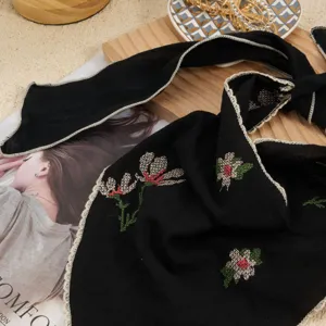 Black embroidered triangle headscarf detail, vintage floral cross-stitch and lace edge.