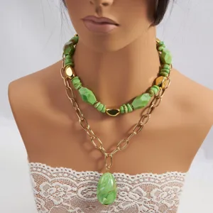 Vista detallada del collar de cuentas de piedra verde multicapa con cadenas doradas.