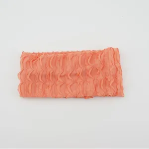 Solid coral pink knitted headband for women with stylish ruffle trim and stretchy design.