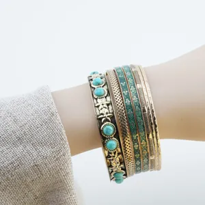 Dettaglio ravvicinato del set di bracciali rigidi dorati vintage con pietra turchese.