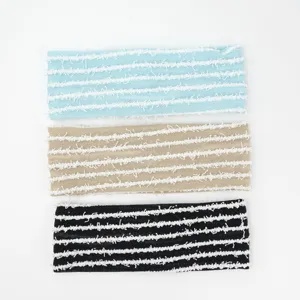 Detailed view of knitted striped headbands featuring textured fringe design in colors.