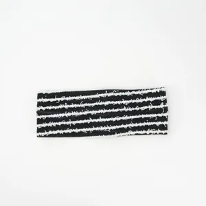 Detail shot of black knitted headband with white stripe texture, showcasing soft fabric.