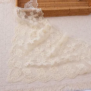Exquisite ivory lace triangle scarf detail with hollow floral embroidery and elegant wavy edges.