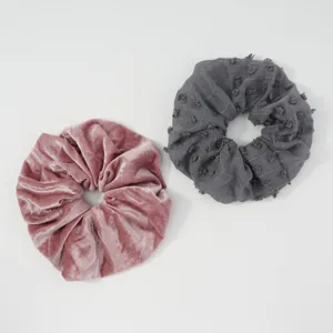 Two stylish hair scrunchies featuring soft pink velvet and grey textured fabric for daily wear.
