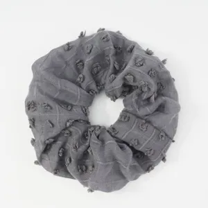 Grey fabric hair scrunchie with tufted dots minimalist style soft hair accessory for women.