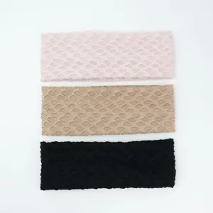 Detailed close-up shot of elastic knitted headbands in pink, khaki, and black colors.