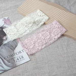Detailed shot of elegant wide lace hairbands in cream and pink, elastic floral design.