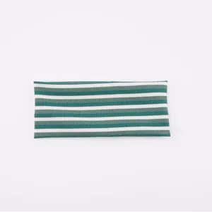 Detailed closeup view of a knitted striped headband, green and white elastic sports hair accessory.